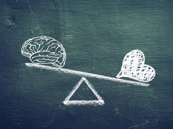 Brain versus heart balance concept in chalk drawing on blackboard.