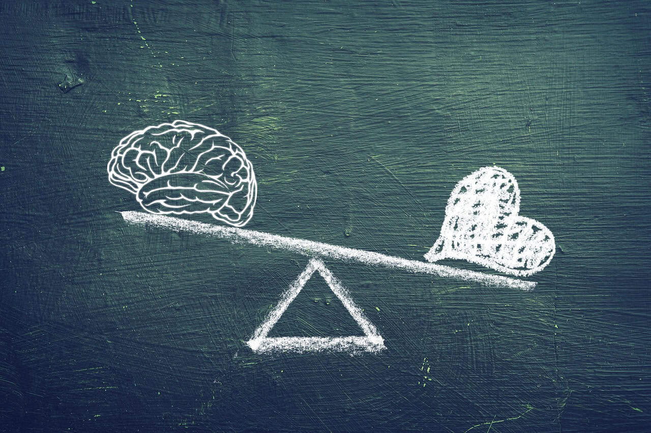 Brain versus heart balance concept in chalk drawing on blackboard.