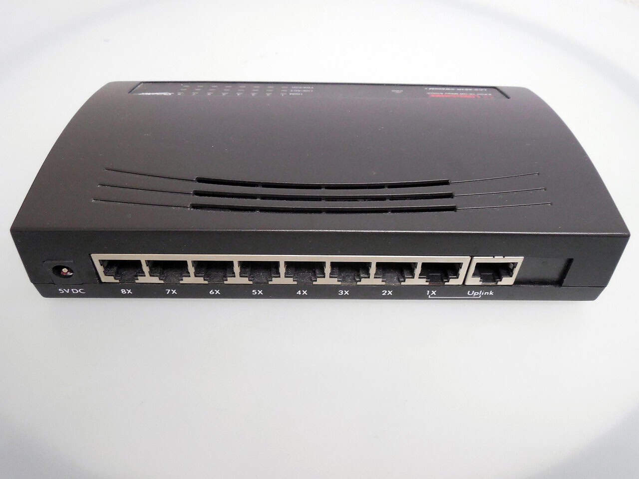 Network switch or router device on a plain white surface, used for internet and network connectivity in a home or office setting.
